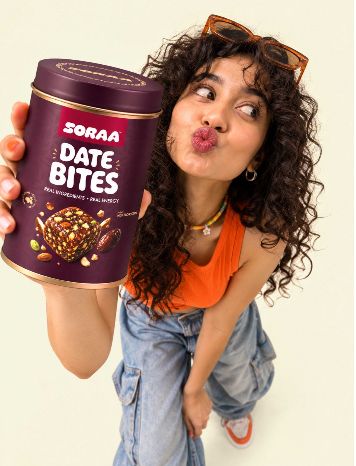 A woman holding a SORAA Date Bites tin